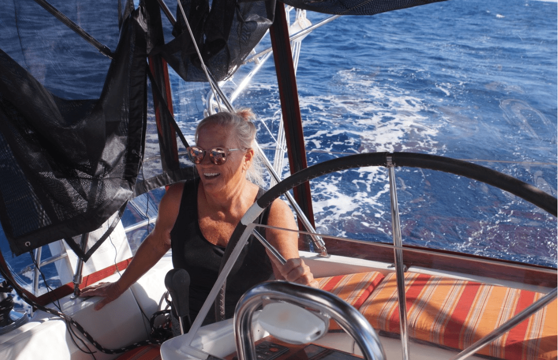 Captain Deb Marlor smiles as she steers her boat along the ocean.