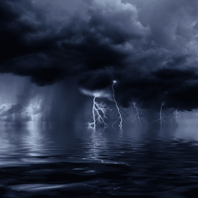 a dark and rainy day on the water, with black clouds over the ocean.