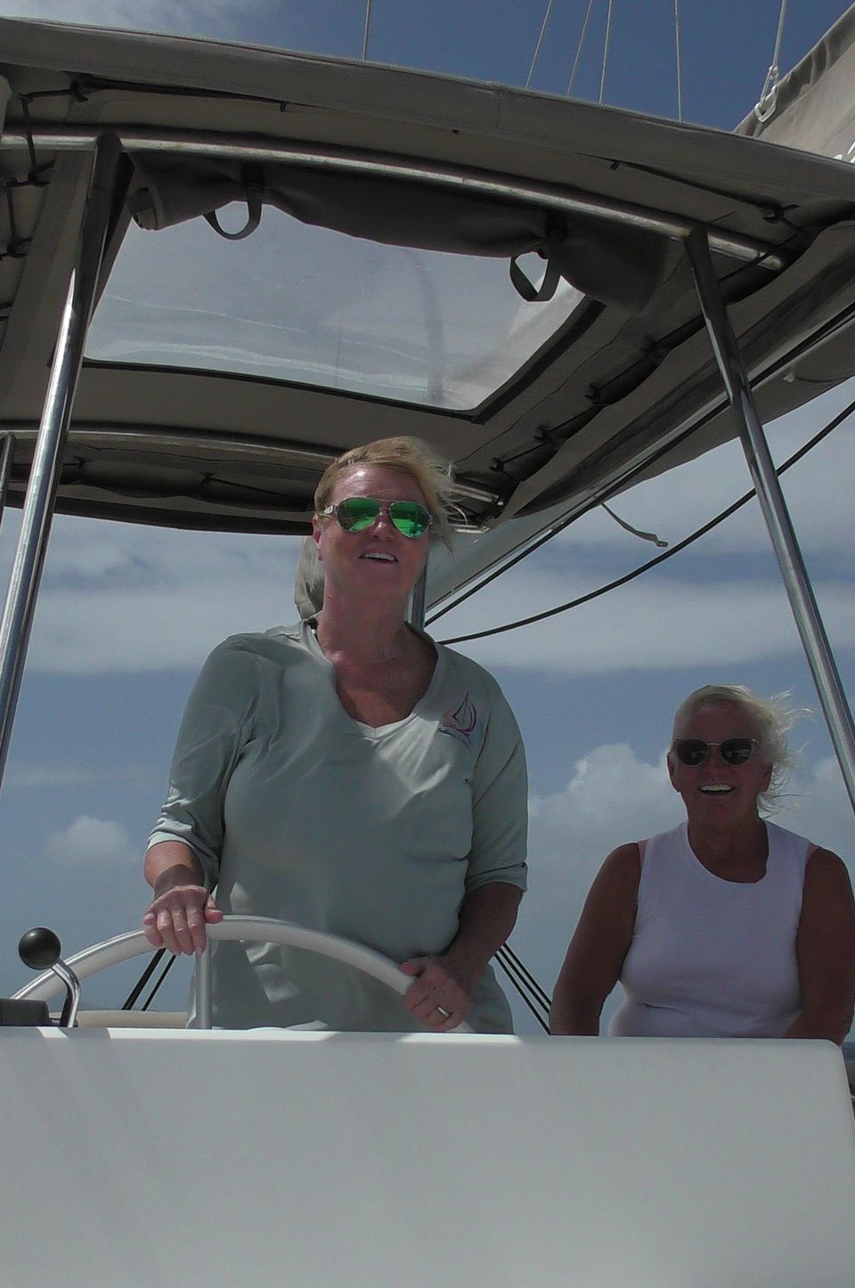 A top-down image of a powerboat being driven along blue seas. There is someone wakeboarding behind the boat.