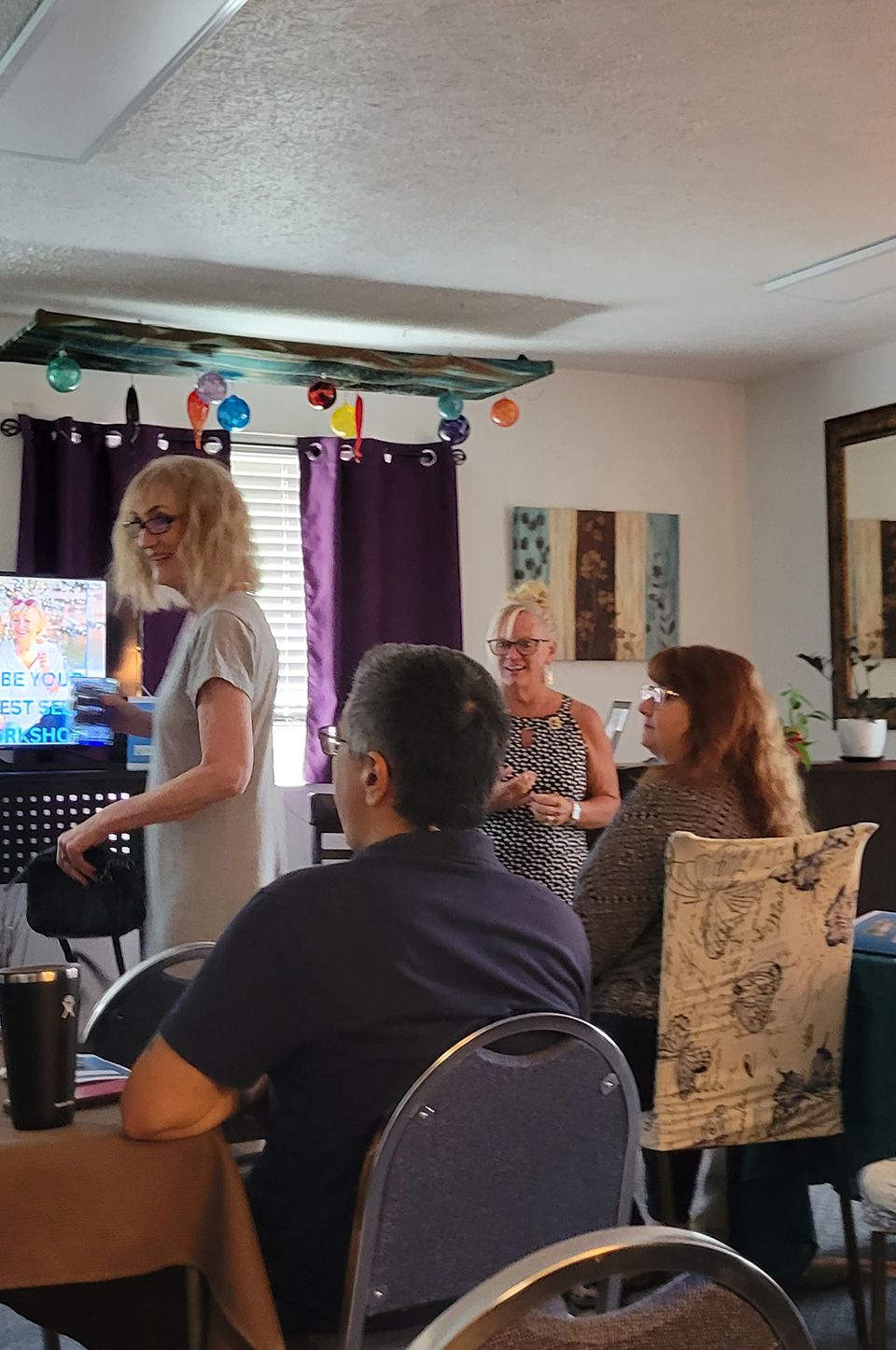 A top-down image of a powerboat being driven along blue seas. There is someone wakeboarding behind the boat.