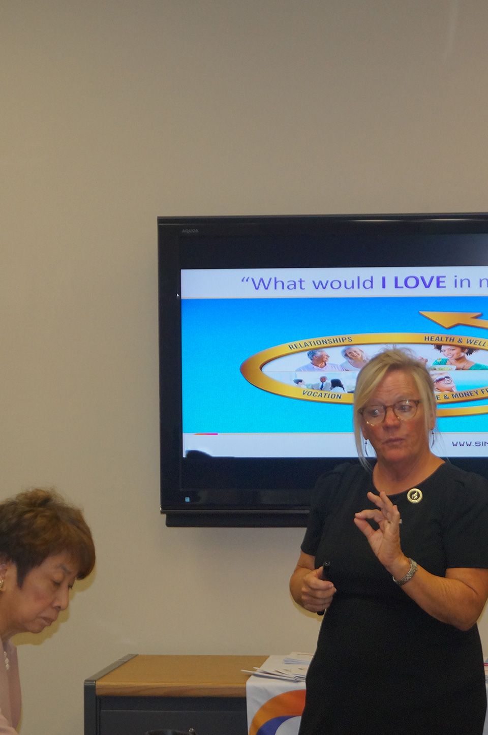 A top-down image of a powerboat being driven along blue seas. There is someone wakeboarding behind the boat.