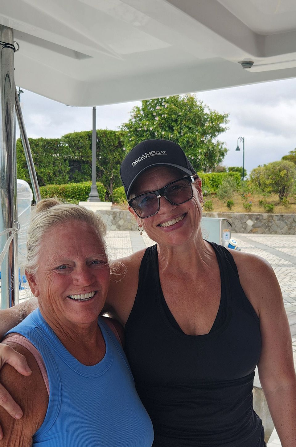 A top-down image of a powerboat being driven along blue seas. There is someone wakeboarding behind the boat.
