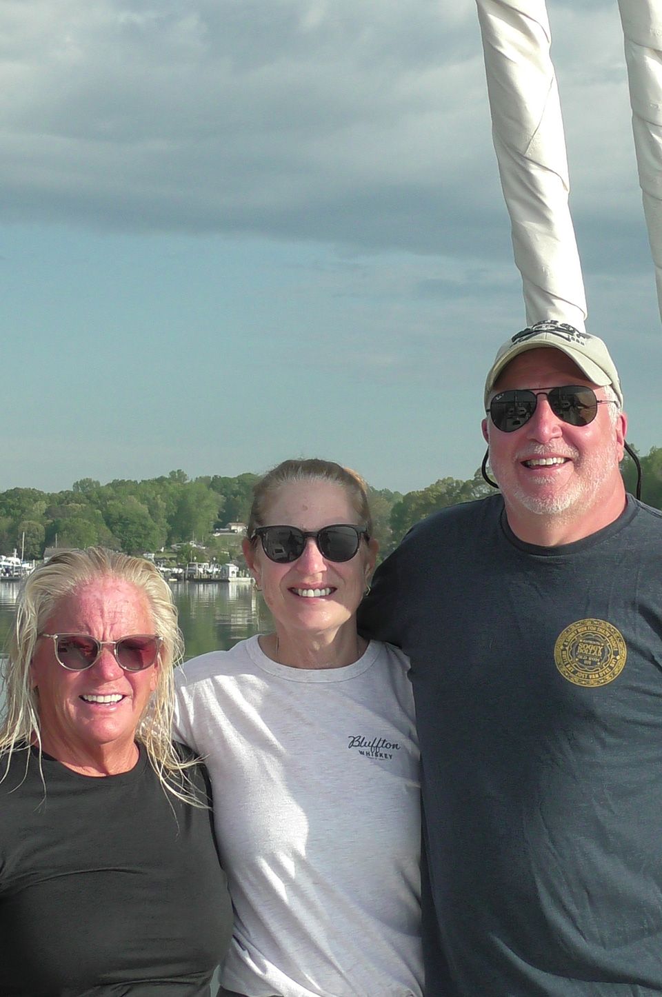 A top-down image of a powerboat being driven along blue seas. There is someone wakeboarding behind the boat.